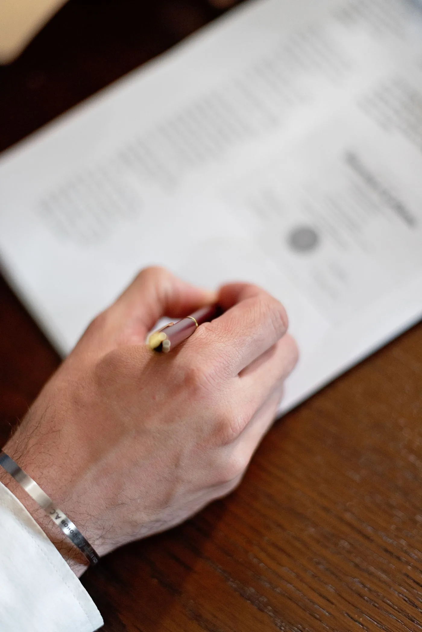 Main d'un entrepreneur signant les documents de constitution de sa société par actions